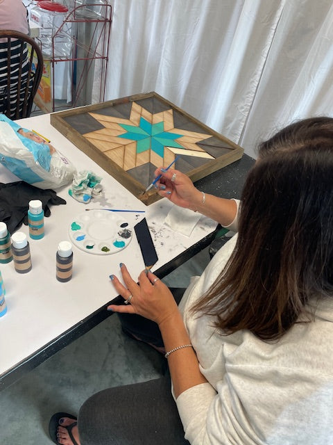 A woman working on painting her sign